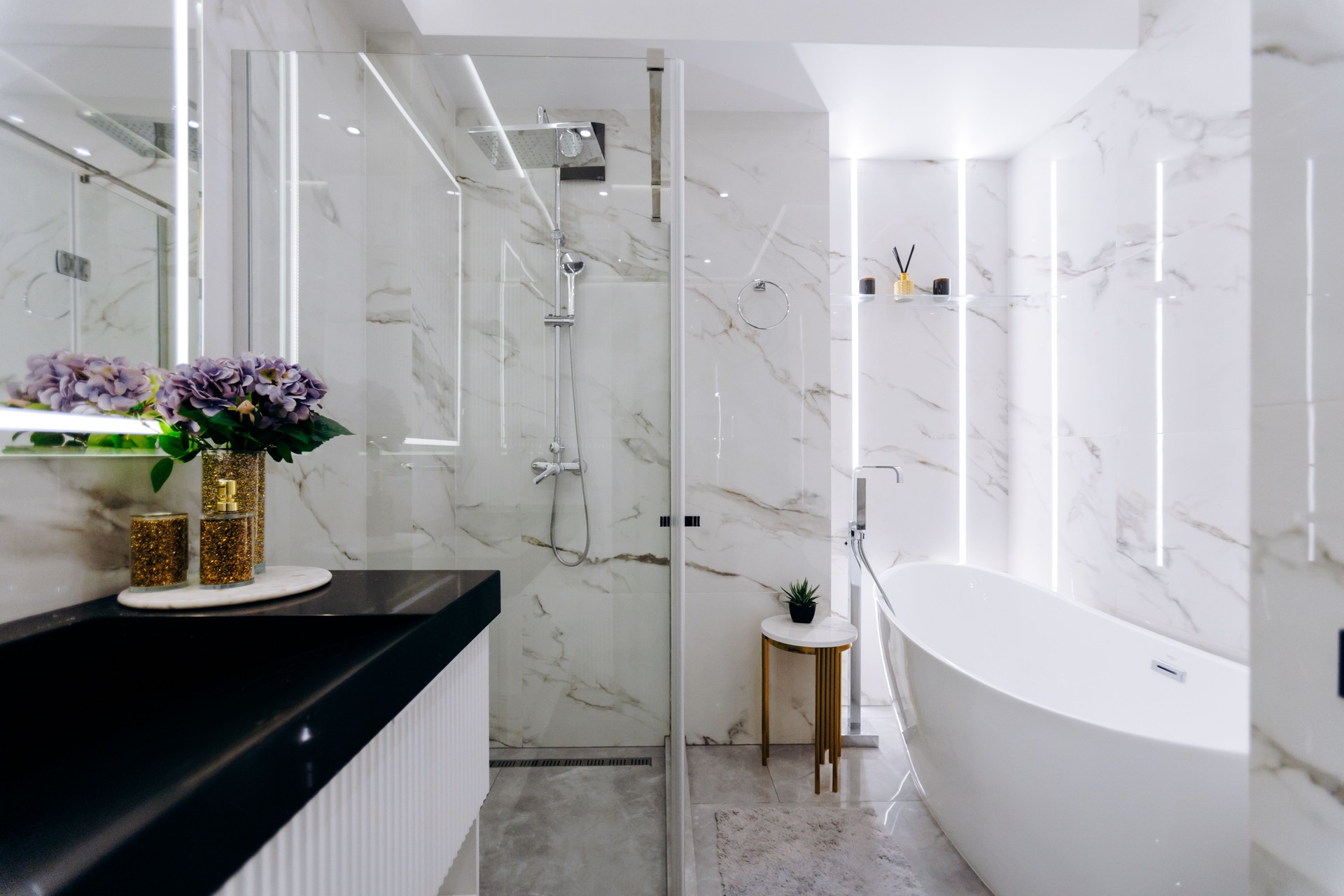 A welldesigned bathroom featuring a bathtub, sink, shower, and mirror